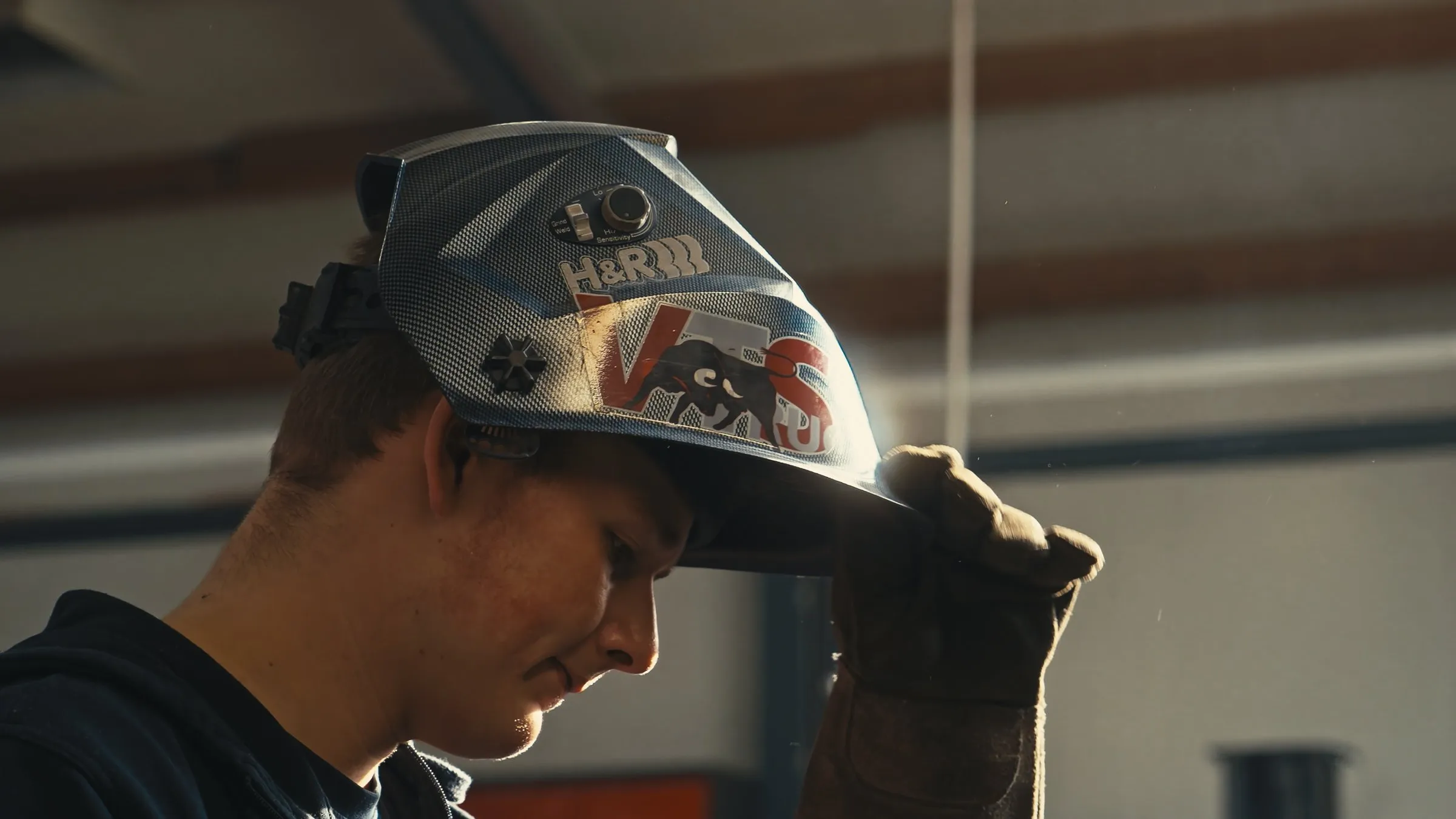 Mitarbeiter der VTS Trucks GmbH mit hochgeklapptem Schweißhelm in der Werkstatt