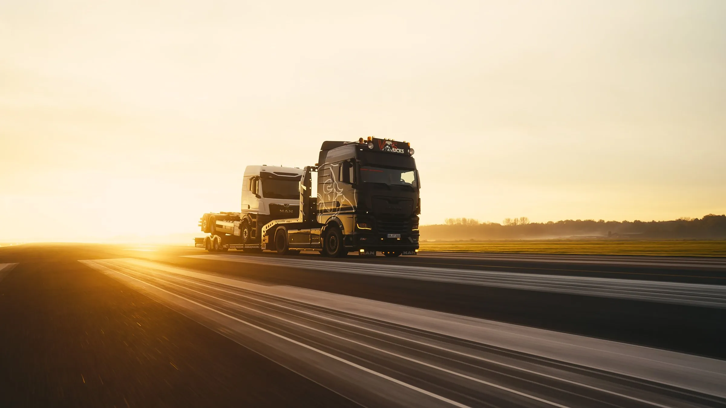 Lkw im Gegenlicht der tiefstehenden Sonne auf einer Landstraße