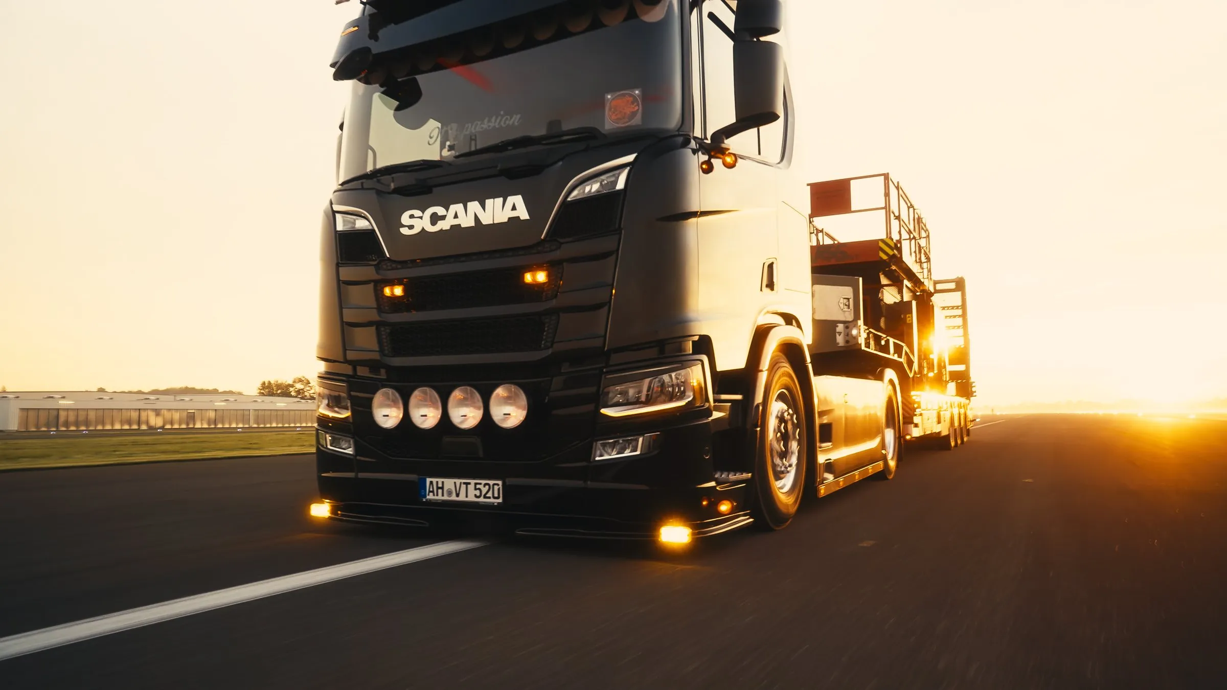 Scania-Sattelzug mit Tieflader im Sonnenuntergang