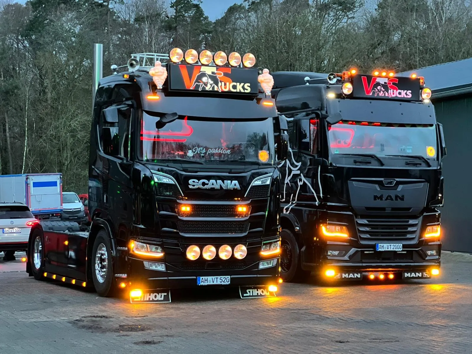 Zwei Scania-Zugmaschinen mit eingeschalteten Zusatzscheinwerfern auf dem Hof